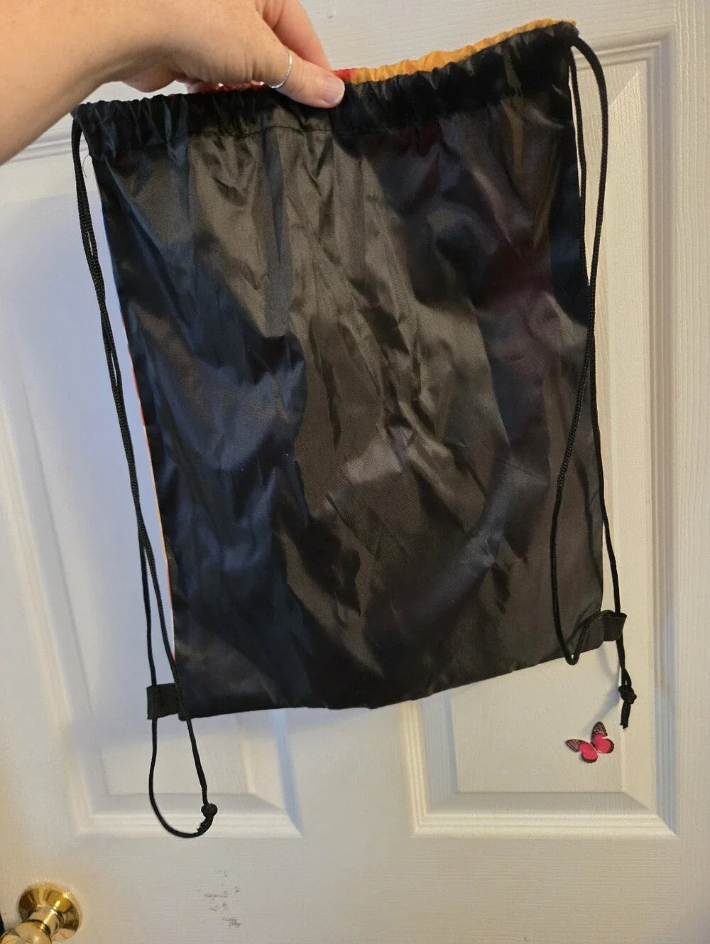 Draw string backpack with a tie dye front print that reads color our world